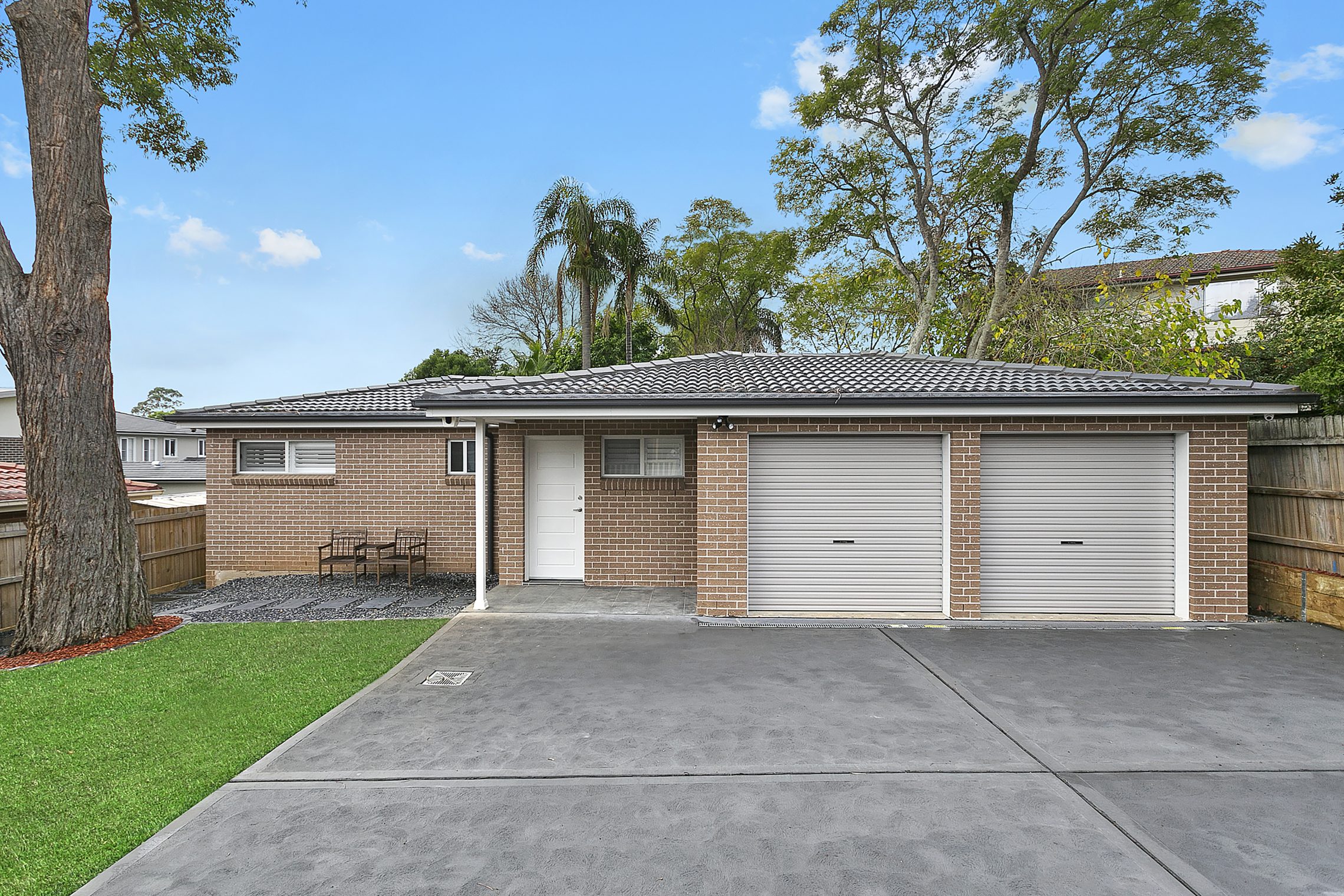 Large driveway leading to two car garage and brick granny flat