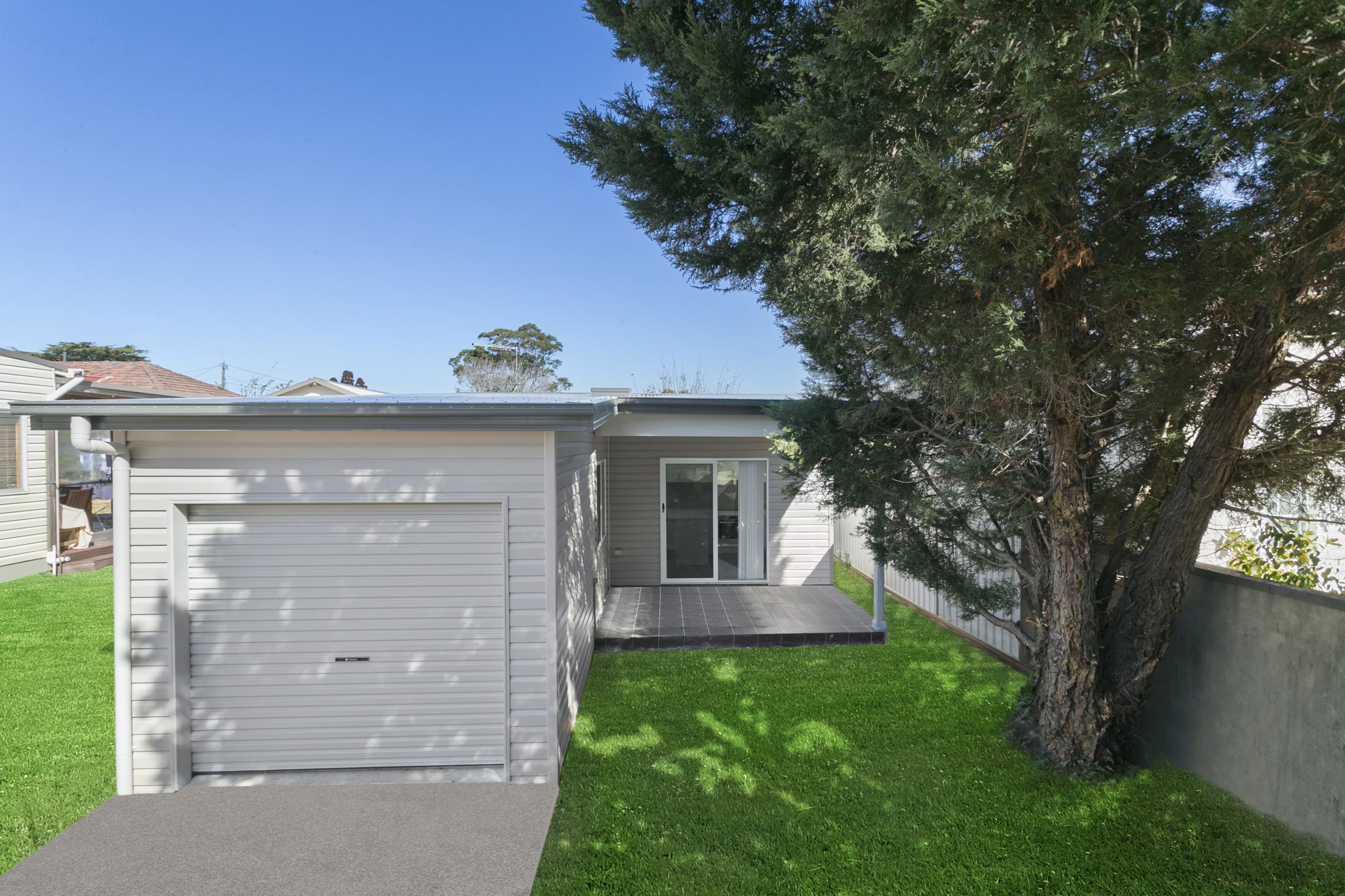 L-shaped granny flat with driveway to garage and patio with entry point further back