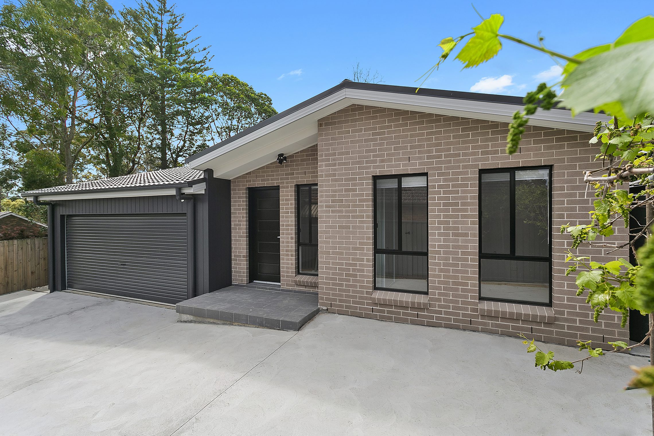 Brick granny flat with black garage and detailing on doors and windows