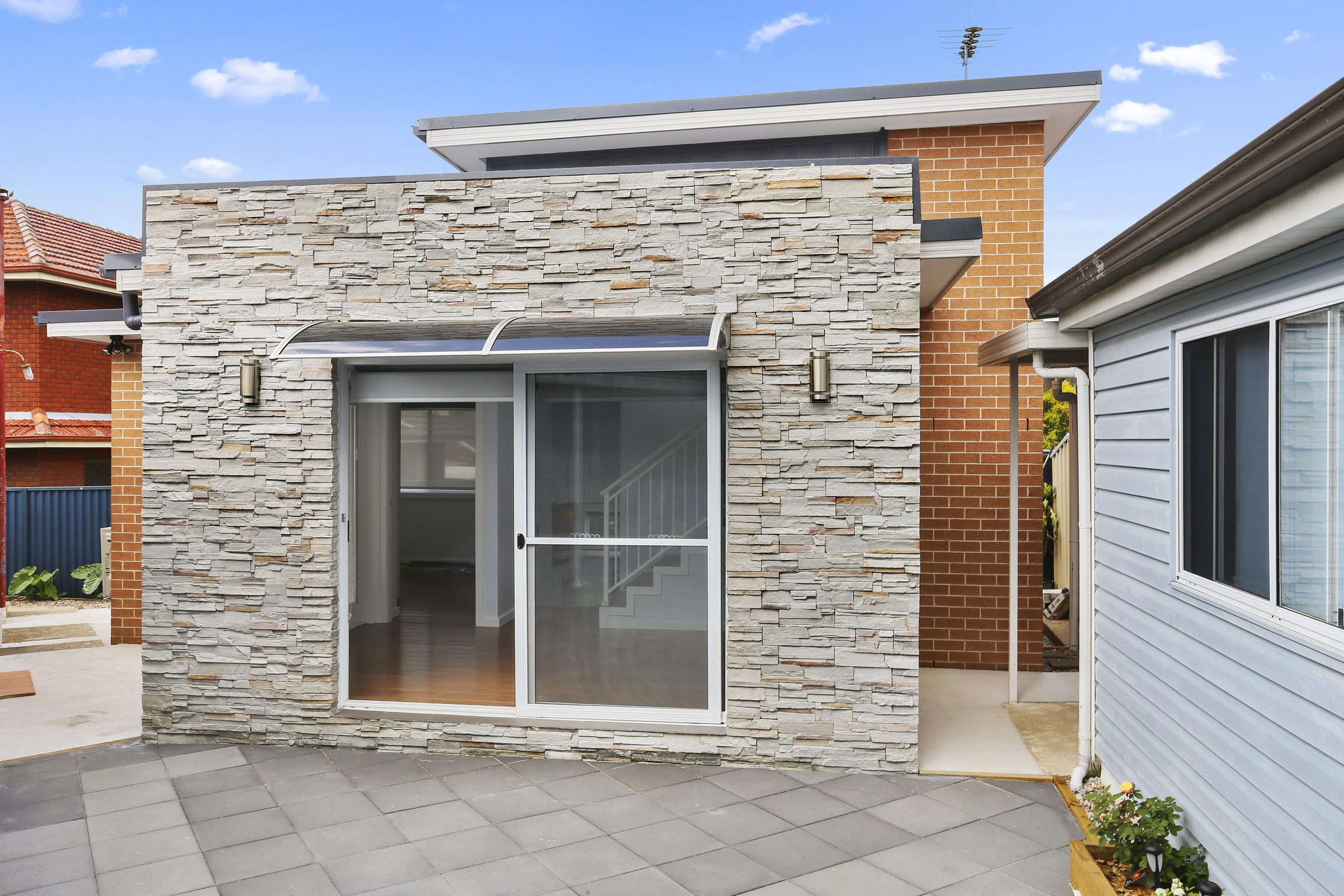 A sliding glass door entry to a stone accented granny flat