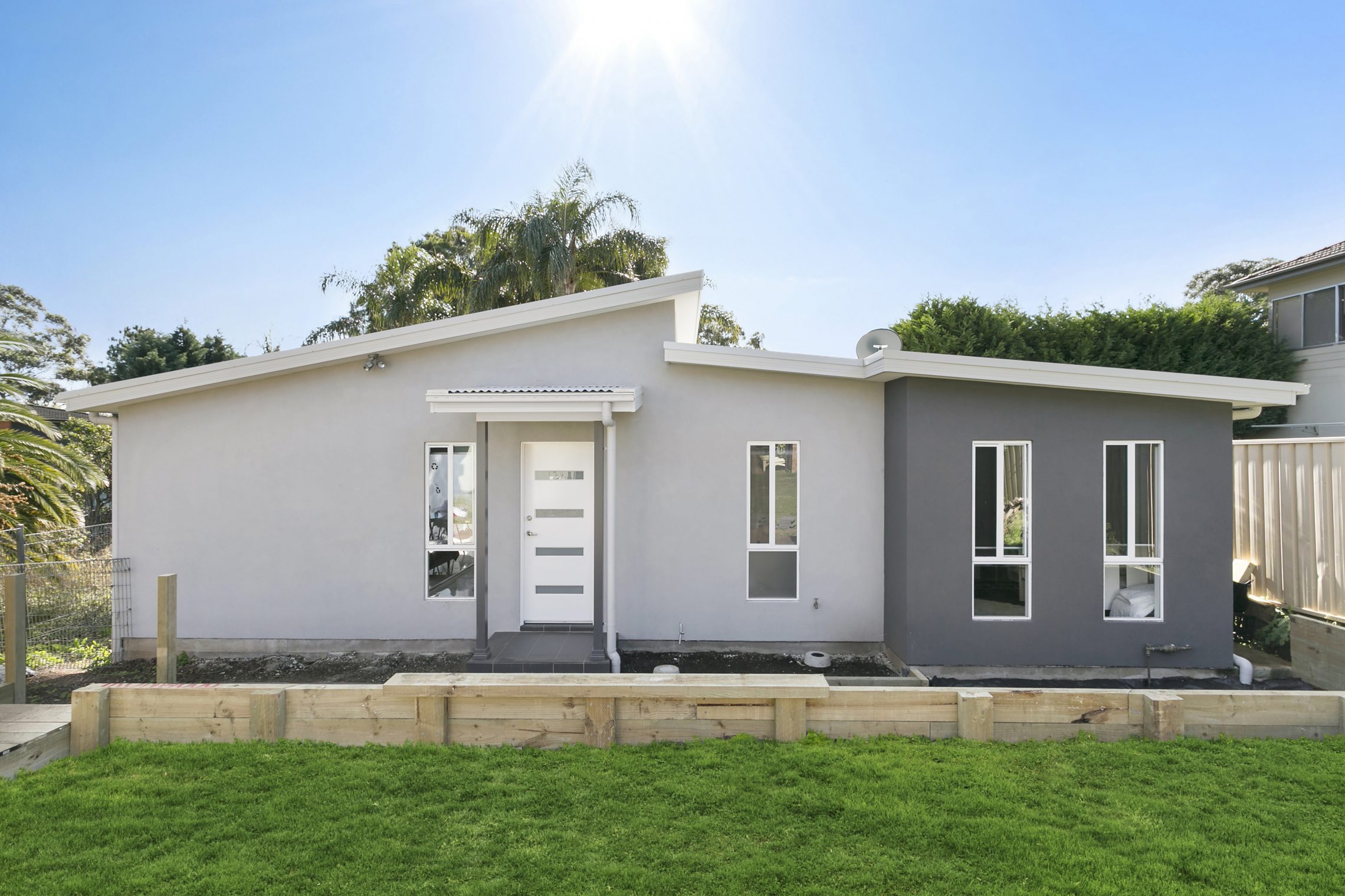 Modern rendered granny flat with sloped roof and covered entry