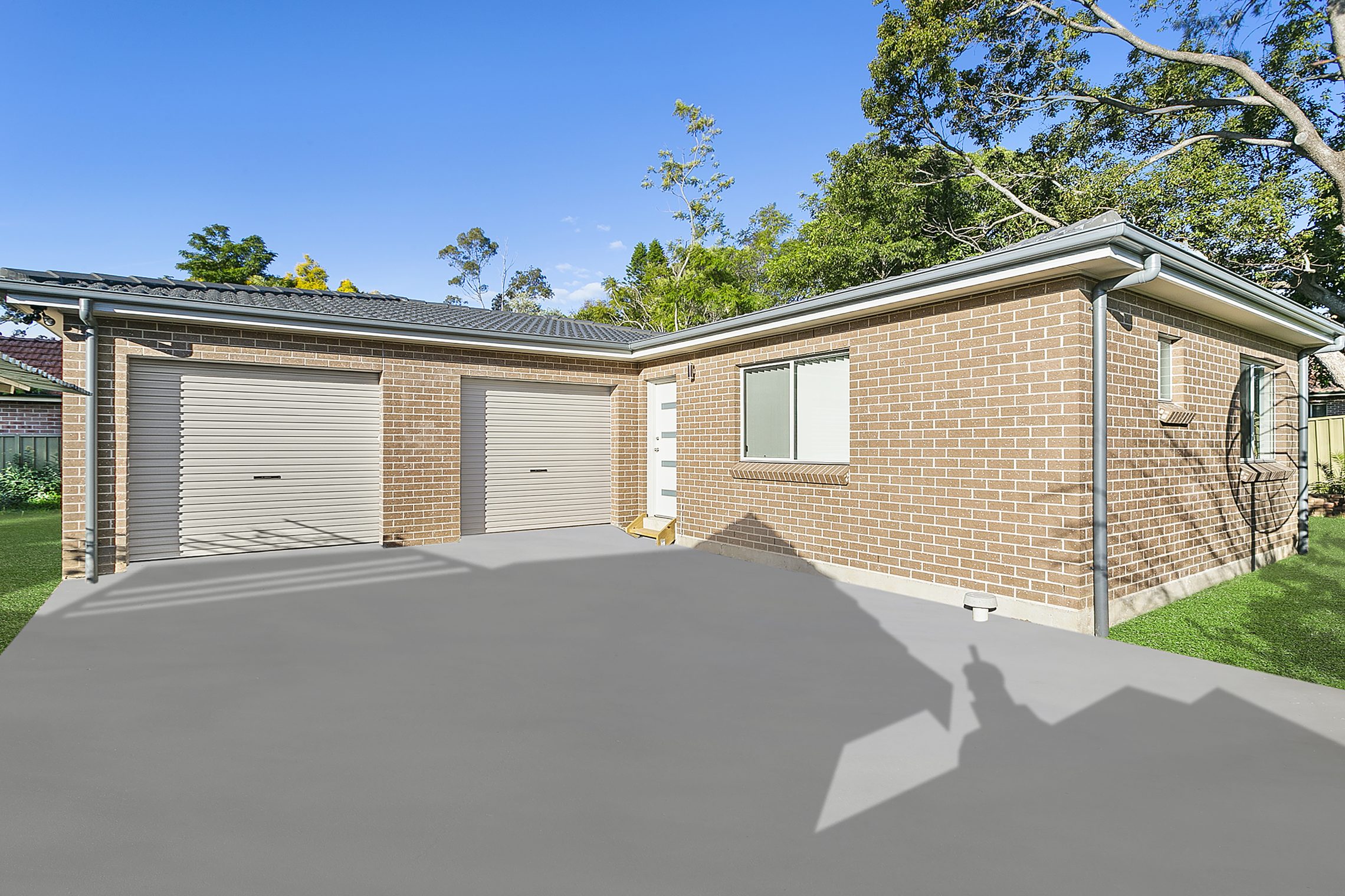 Large driveway leading to two car garage and front door entry point