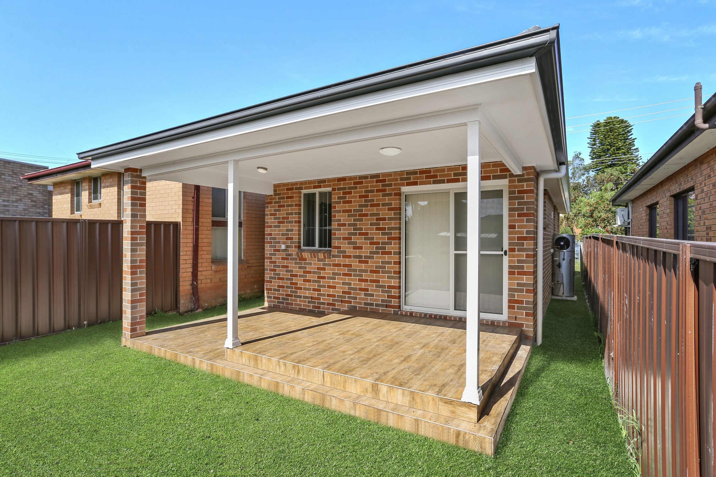 Grass surrounded granny flat with two tiered covered patio