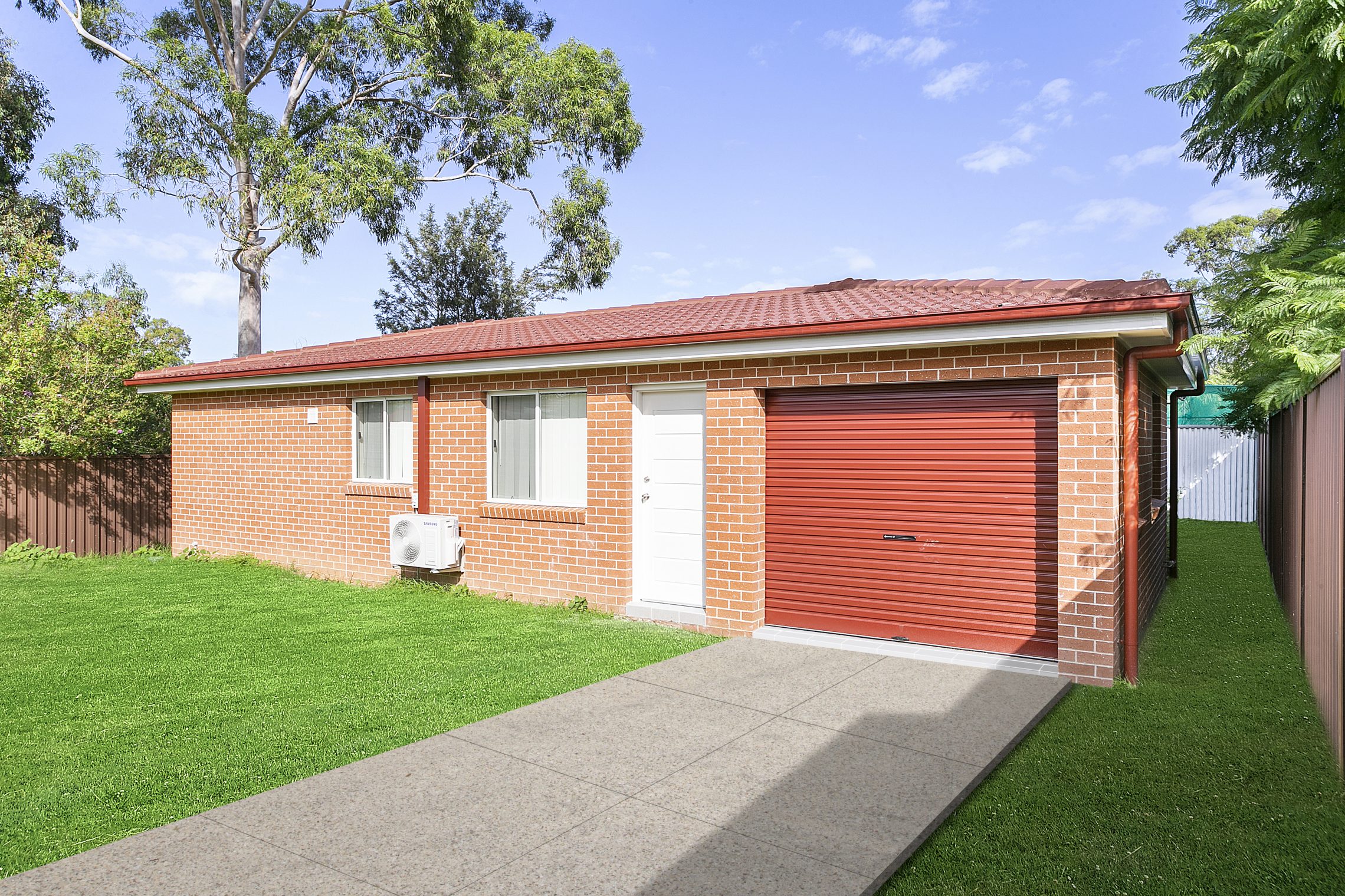 Grass surrounded granny flat with driveway and garage