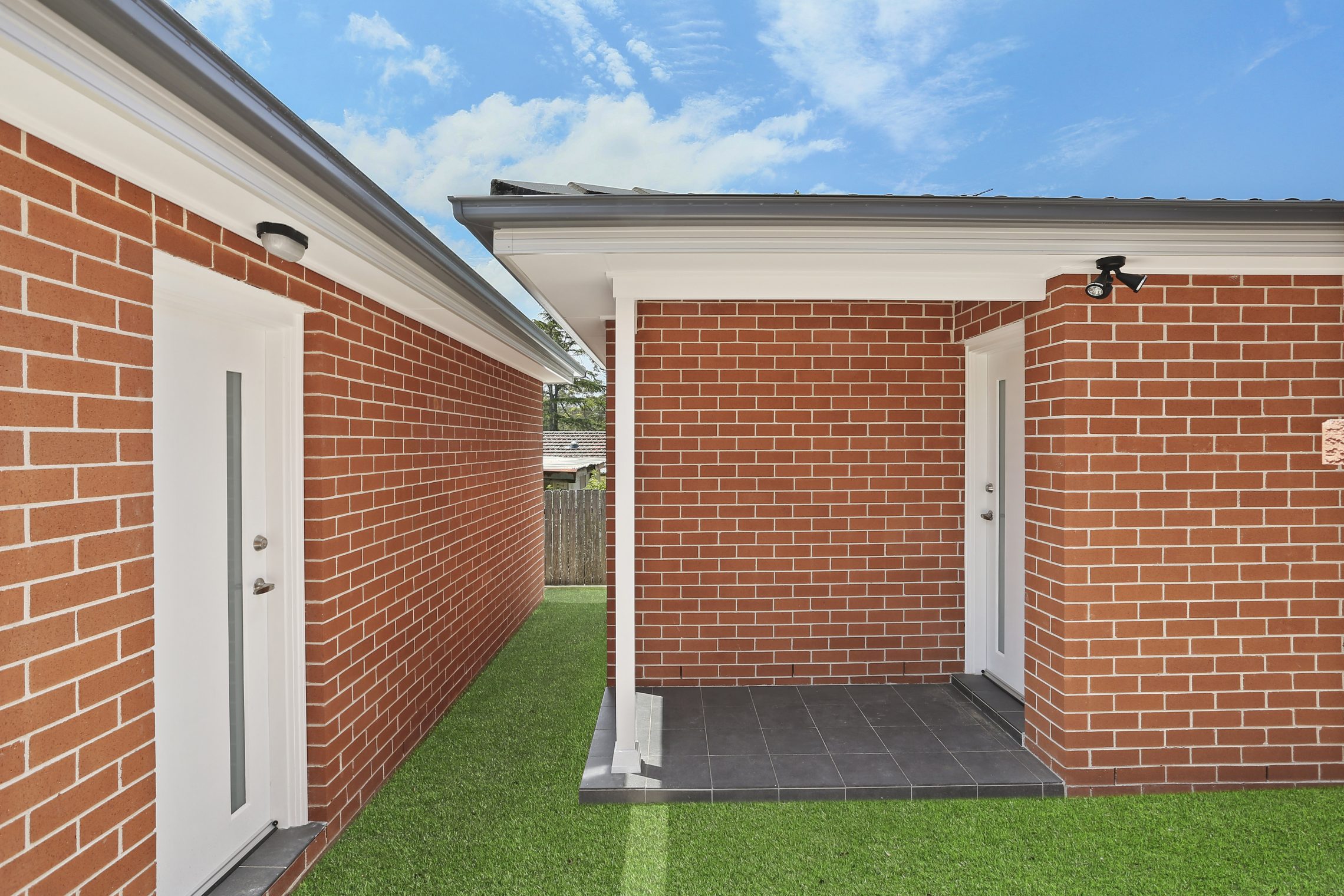 The entry to a brick granny flat a few meters away from the exit of another brick flat