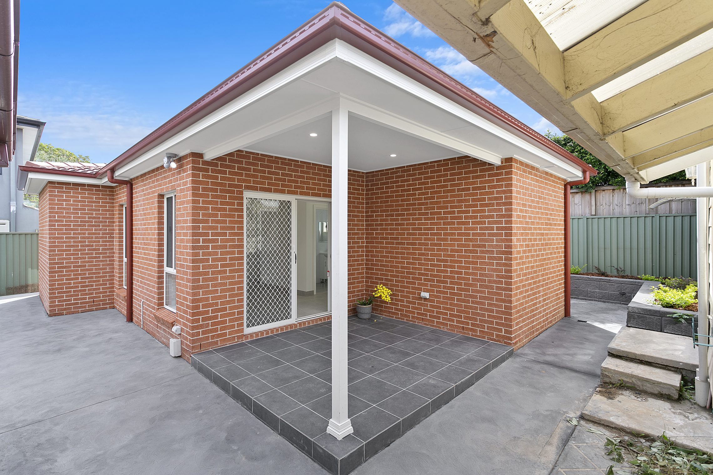 Brick granny flat with small covered patio outside of entry point 