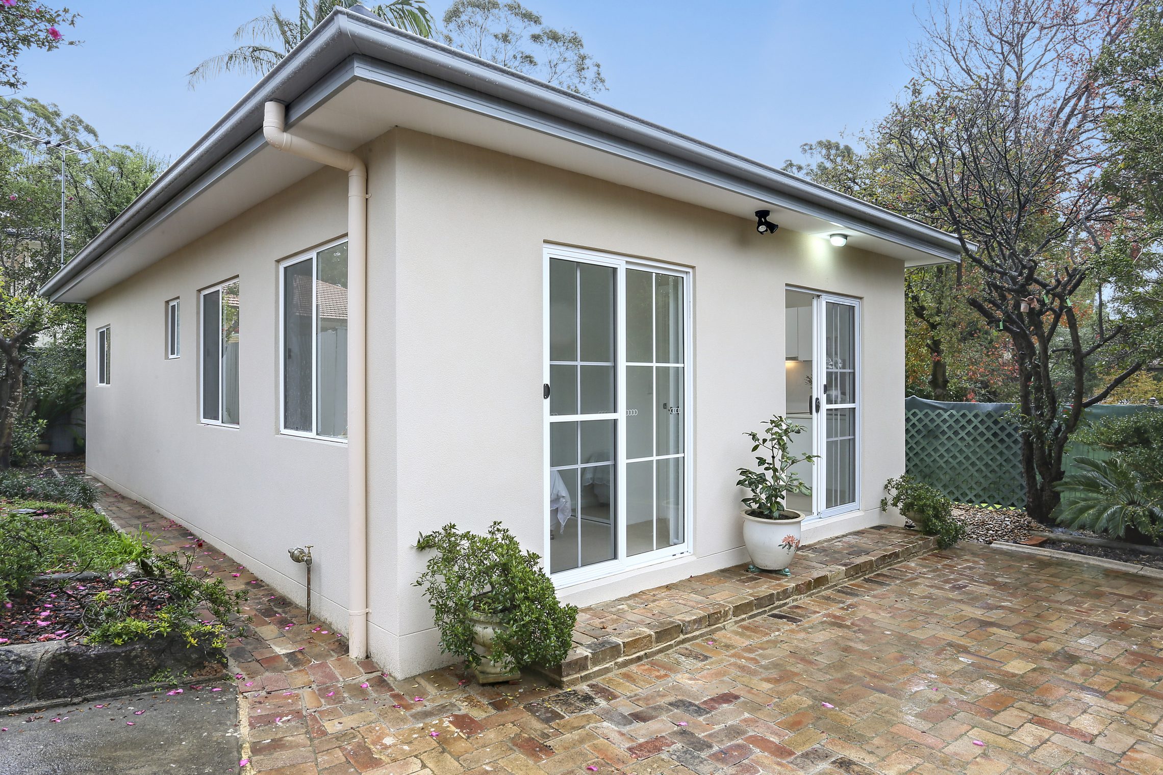 Vintage brick patio connected to entry point of small bright granny flat