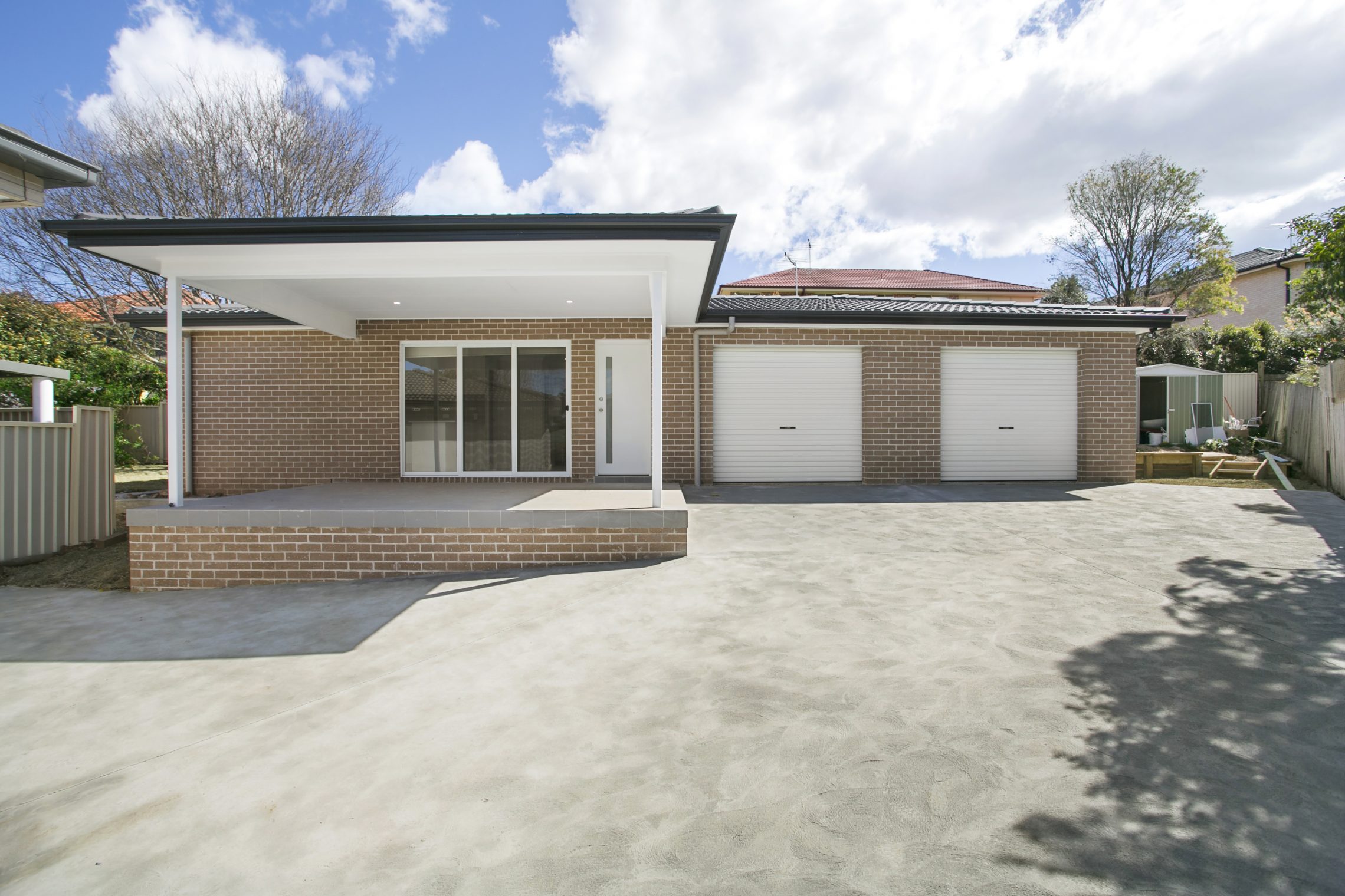 Large driveway leading to two car garage and large covered front cement porch