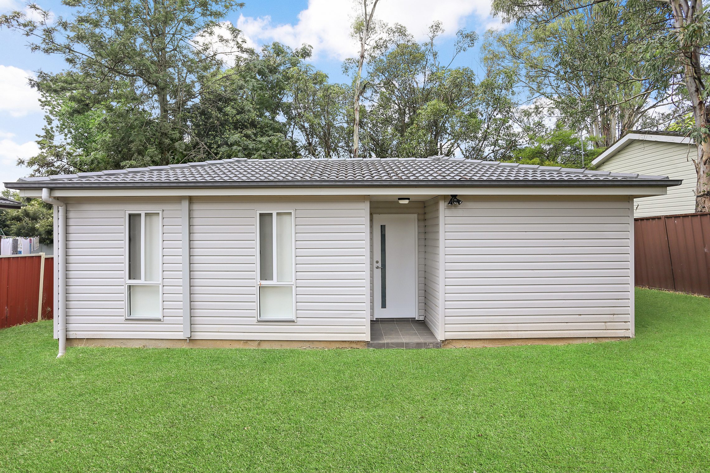 Grass surrounded granny flat with enclosed and covered small entry point