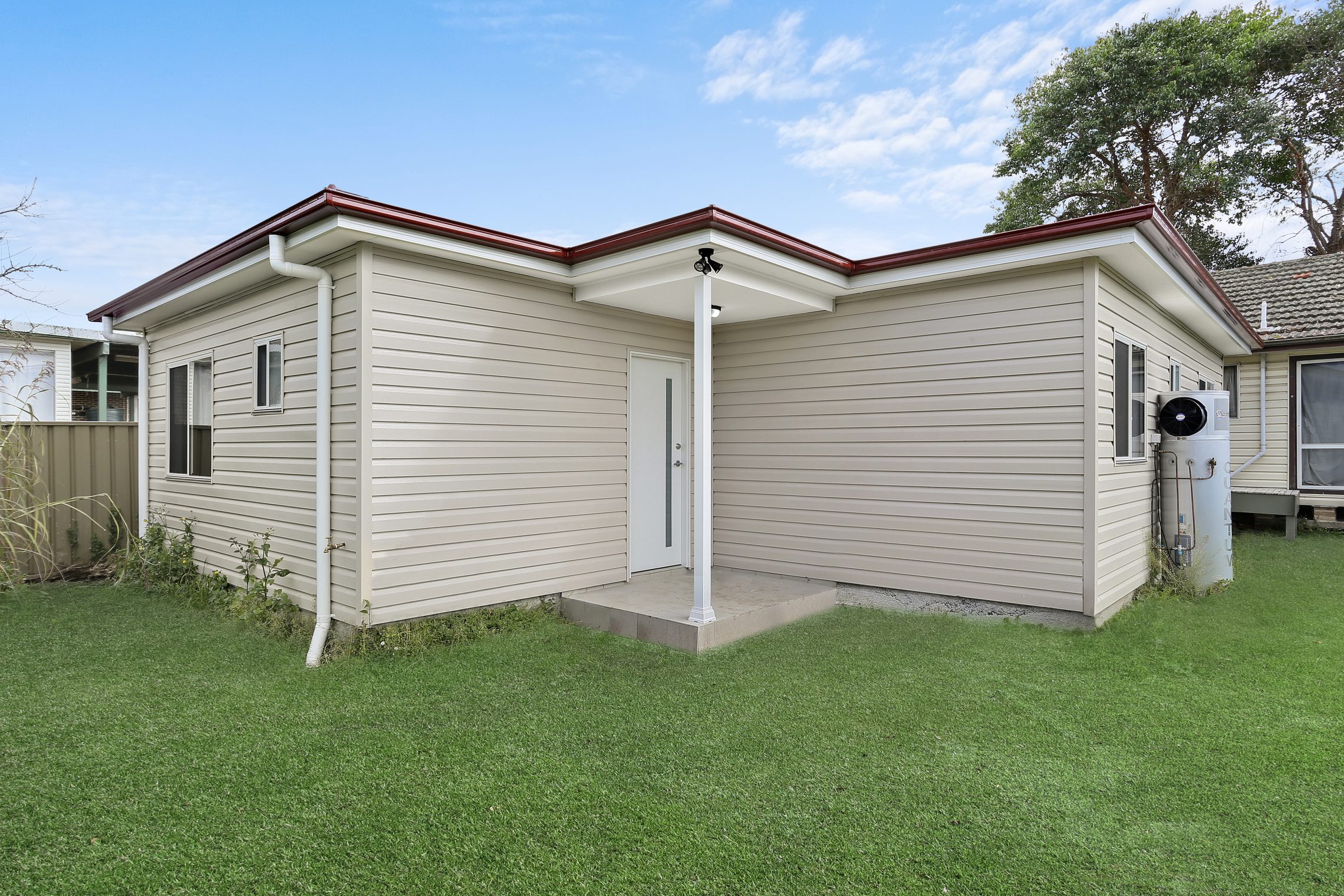 Granny Flat with small covered entry point surrounded by grass