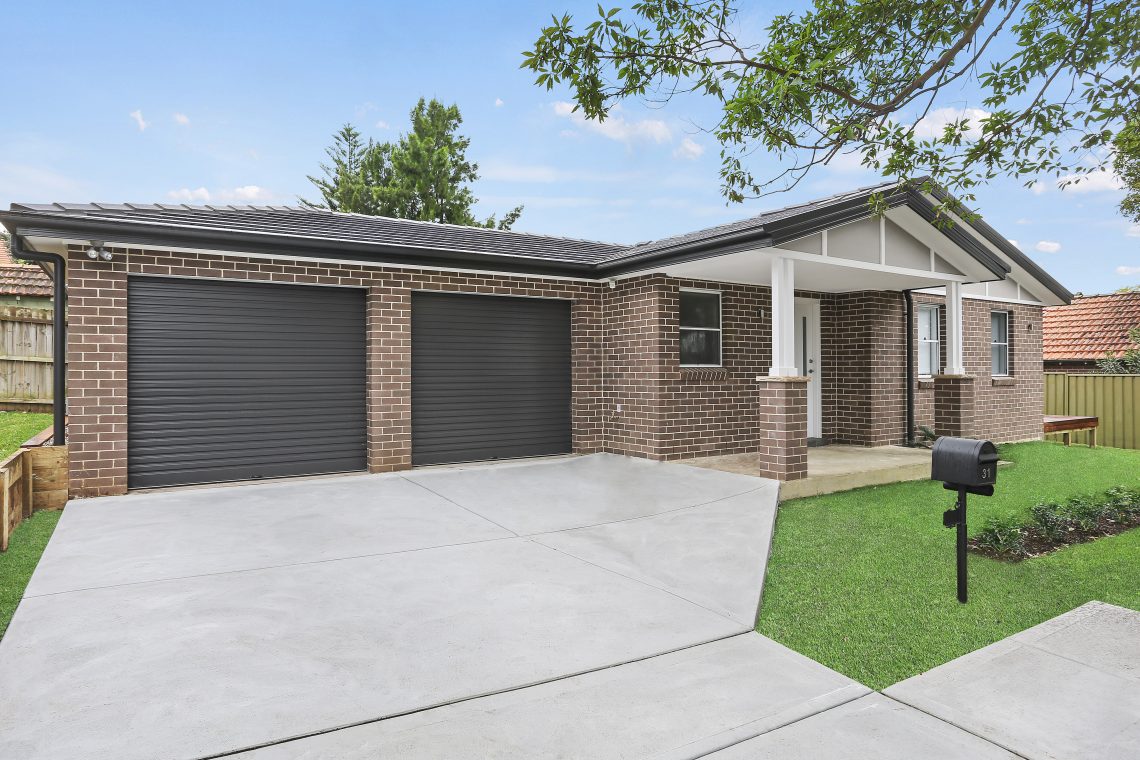 Driveway leading to modern brick granny flat with two car garage and covered entry