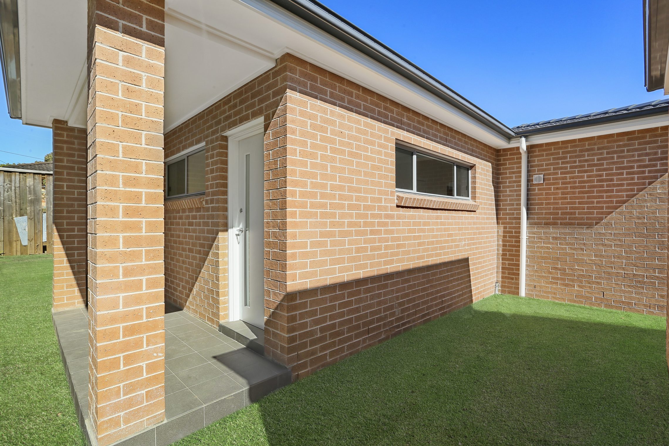 The front step and covered entry into a brick granny flat