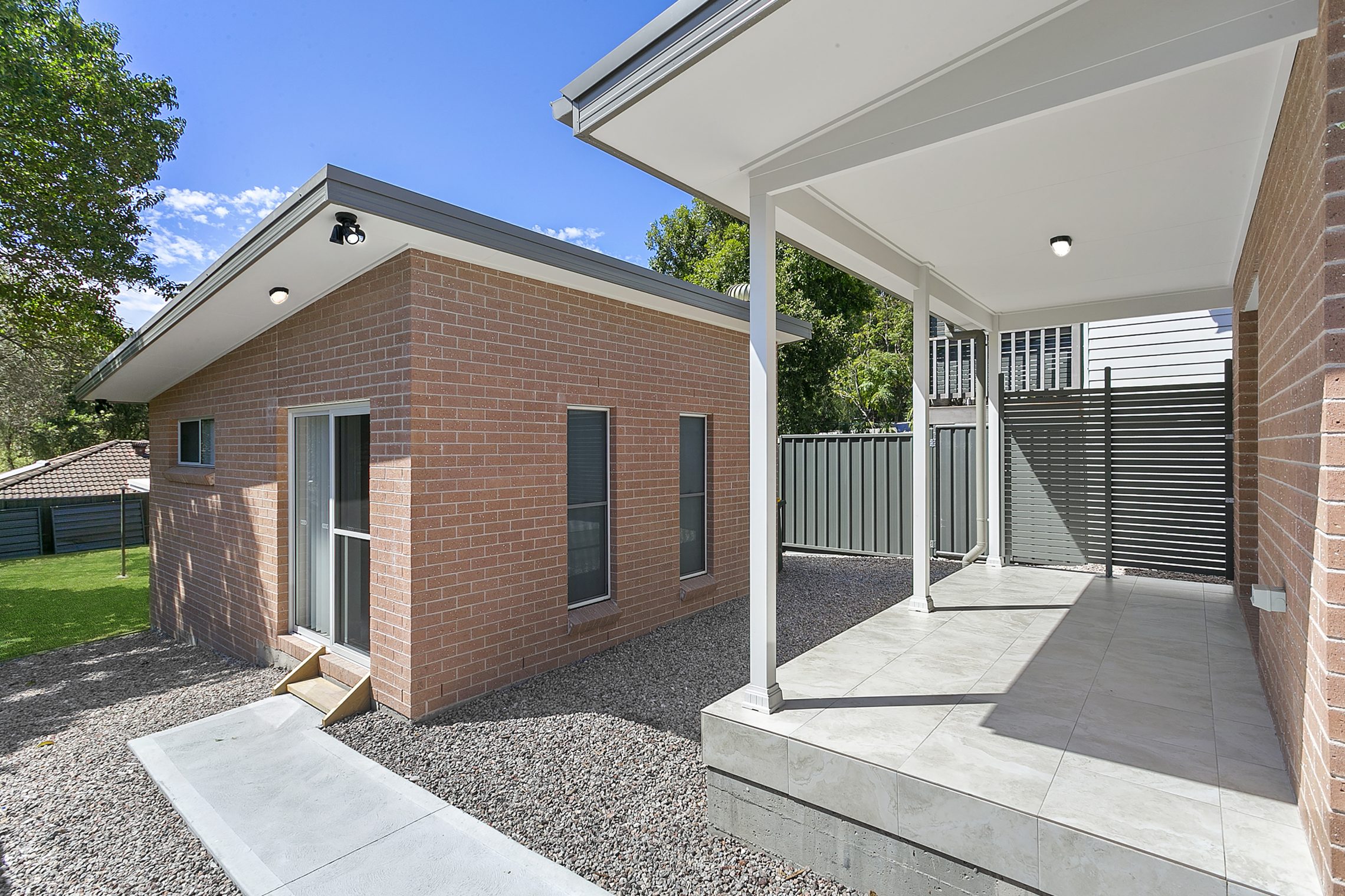 Walkway leading to the front door of a small brick granny flat