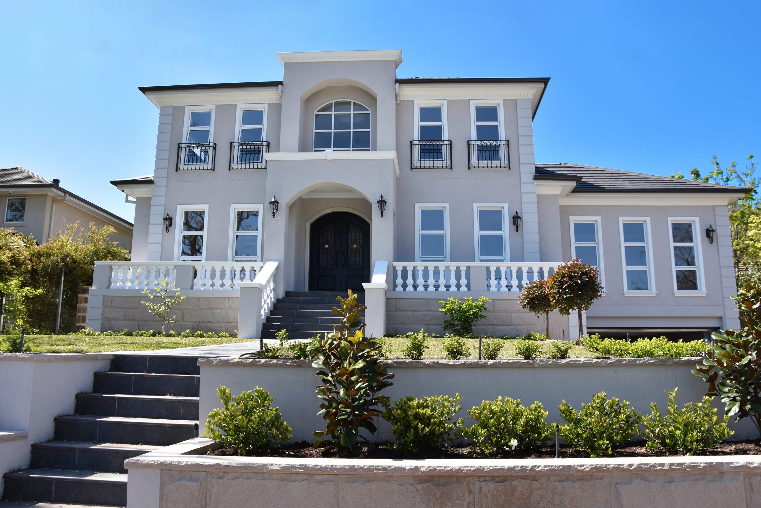 two level house with stairway leading to covered entry from sidewalk