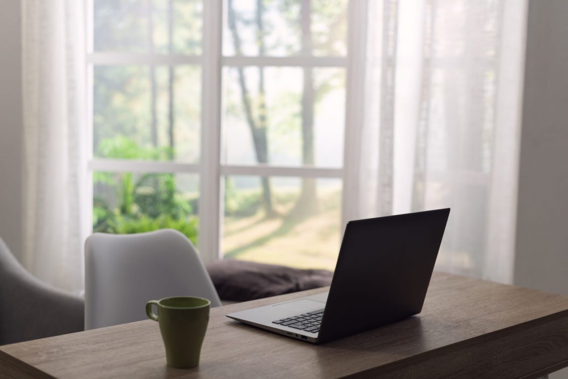 computer on desk by a window