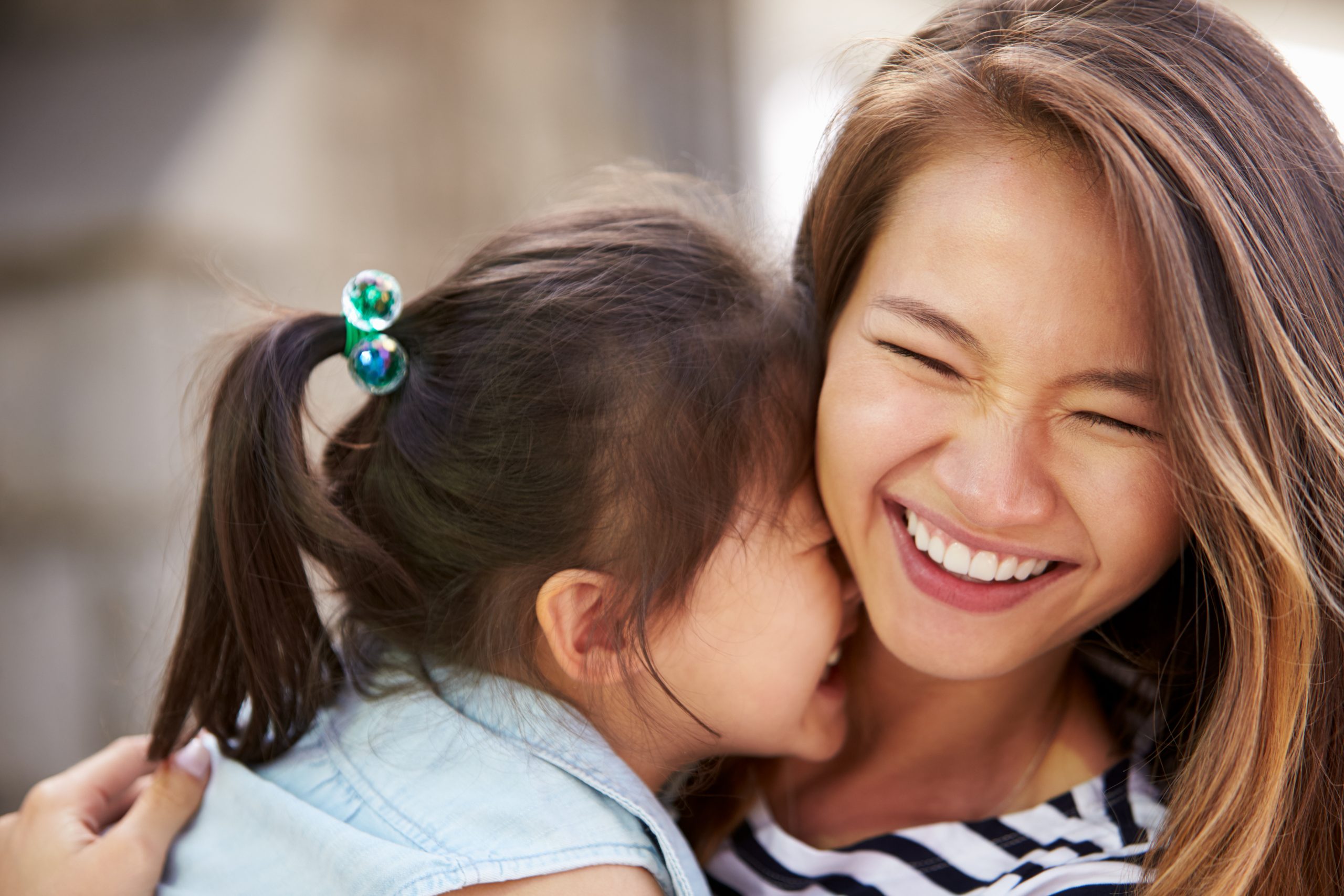 a mom and daughter laughter together