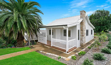 white granny flat with white picket fence