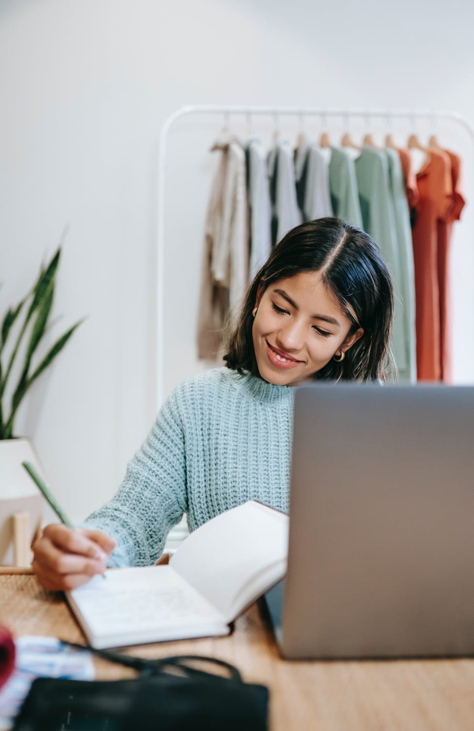 a happy woman in a blue jumper, working in a pod