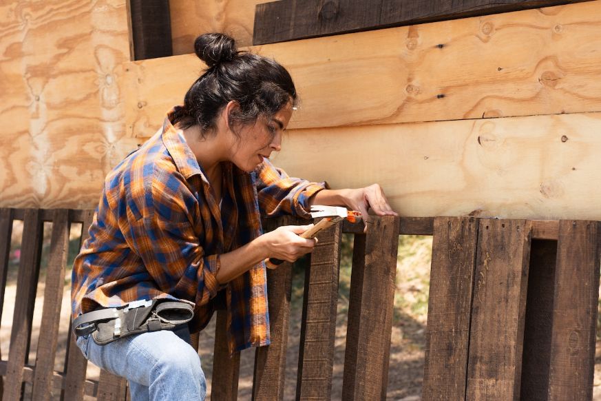 Woman hammering house